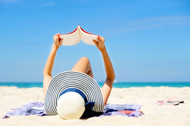 Frau, die am Strand liest